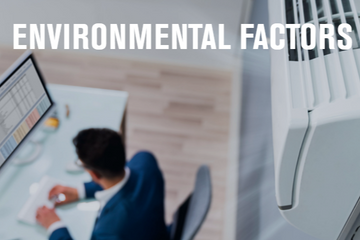 Office worker at a desk near an air conditioner, highlighting environmental factors in the workplace.