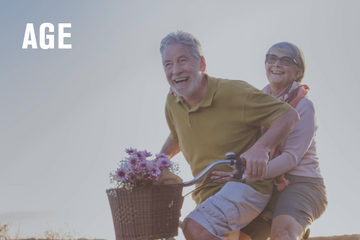 Happy elderly couple riding a bicycle together, symbolizing aging and active lifestyle.