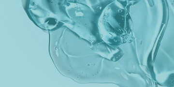 A close-up of a translucent, aqua-colored gel texture with bubbles and smooth, flowing shapes, set against a matching light blue background.