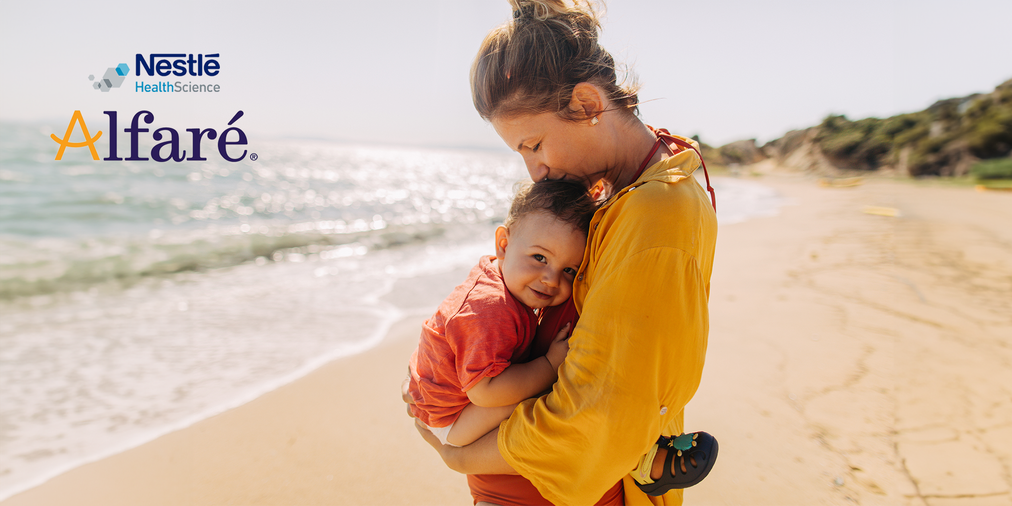 A loving mother in a yellow outfit is holding her smiling toddler, dressed in red, on a sunny beach with gentle waves in the background. In the top left corner, the logos for "Nestlé Health Science" and "Alfaré" are displayed. The atmosphere is warm and serene, reflecting a moment of care and affection. Alfaré is a specialized infant formula by Nestlé Health Science, designed to support the unique nutritional needs of infants with food allergies. Available on shop.prohealth.com.mt and from pharmacies.